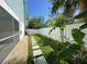 Backyard showing a stepping stone pathway and privacy fence with lush tropical landscaping at 16204 3Rd E St, Redington Beach, FL 33708