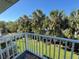 Balcony view of the green, lush backyard and tropical palm trees at 16204 3Rd E St, Redington Beach, FL 33708