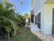 Backyard featuring a screened porch, stepping stone pathway and lush tropical landscaping at 16204 3Rd E St, Redington Beach, FL 33708