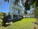 Charming blue two-story home boasts a large backyard, fire pit, and lush tropical landscaping at 16204 3Rd E St, Redington Beach, FL 33708