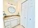 Bathroom features a stylish vanity, round mirror, lighting, and a spacious closet at 16204 3Rd E St, Redington Beach, FL 33708