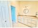Bright bathroom vanity with white cabinets, light countertop, and a stylish round mirror at 16204 3Rd E St, Redington Beach, FL 33708