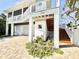 Beautiful raised home featuring a two-car garage and outdoor staircase leading to the entrance at 16204 3Rd E St, Redington Beach, FL 33708
