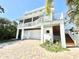 Charming coastal home featuring an elevated design, a two-car garage, and lush landscaping at 16204 3Rd E St, Redington Beach, FL 33708