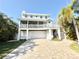 Charming coastal home featuring a two-car garage, a screened porch and a brick paver driveway at 16204 3Rd E St, Redington Beach, FL 33708