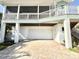 Elevated two-car garage beneath home with convenient access from a brick driveway at 16204 3Rd E St, Redington Beach, FL 33708