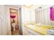 Well-lit bathroom featuring a sink, vanity, mirror, and patterned wallpaper at 1655 S Highland Ave # F126, Clearwater, FL 33756