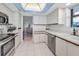 Condo kitchen with white cabinets, stainless steel appliances, and an open layout connecting to the living area at 1660 Gulf Blvd # Ph-7, Clearwater Beach, FL 33767