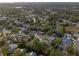A charming neighborhood with lush trees, ponds, and diverse housing styles from above at 1686 Spottswood Cir, Palm Harbor, FL 34683