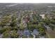 Aerial view highlighting a neighborhood and home's location within a community with mature trees and lush landscapes at 1686 Spottswood Cir, Palm Harbor, FL 34683