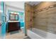 Stylish bathroom featuring a tiled shower and bathtub combination, complemented by a wood vanity and contemporary fixtures at 1686 Spottswood Cir, Palm Harbor, FL 34683
