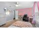 Lovely bedroom with a pink accent wall, desk space, and a playful mermaid-themed wall decoration at 1686 Spottswood Cir, Palm Harbor, FL 34683