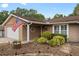 Exterior of a well-kept home featuring mature landscaping and an American flag at 1686 Spottswood Cir, Palm Harbor, FL 34683