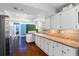 Bright kitchen with white cabinets, modern appliances, and hardwood flooring, extending into a living area at 1686 Spottswood Cir, Palm Harbor, FL 34683