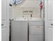 Functional laundry room with a washer, dryer, and overhead shelving, providing practical storage solutions at 1686 Spottswood Cir, Palm Harbor, FL 34683