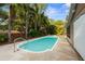 A serene pool area with mature palms and stone decking is perfect for relaxation and outdoor entertaining at 1686 Spottswood Cir, Palm Harbor, FL 34683