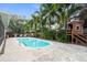 Backyard pool with a charming playhouse, patio, and lush tropical landscaping create a private outdoor retreat at 1686 Spottswood Cir, Palm Harbor, FL 34683