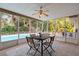 Outdoor dining area with ceiling fan and tile flooring adjacent to the pool at 1686 Spottswood Cir, Palm Harbor, FL 34683