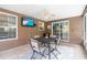 Covered outdoor dining area with ceiling fan and tile flooring at 1686 Spottswood Cir, Palm Harbor, FL 34683