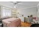 Charming bedroom featuring warm wood floors, a vanity area, and soft pink bedding at 170 Foxfire Ln, Oldsmar, FL 34677