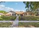 Charming single-story home featuring a well-manicured lawn, inviting entryway, and appealing brick facade at 170 Foxfire Ln, Oldsmar, FL 34677