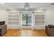 Office featuring built-in bookshelves, bright window views of the pool, and hardwood floors at 170 Foxfire Ln, Oldsmar, FL 34677