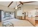 Open living space featuring wood beams, neutral carpeting, and backyard pool views at 170 Foxfire Ln, Oldsmar, FL 34677