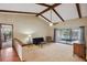 Cozy living room with wood beams, carpeting, a sliding glass door to the backyard pool area, and neutral colors at 170 Foxfire Ln, Oldsmar, FL 34677