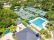 Aerial view of community pool, tennis courts, clubhouse, and lush landscaping, offering a resort-style atmosphere at 18002 Forest Retreat Ln, Tampa, FL 33647