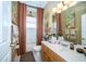 Well-lit bathroom featuring a single vanity, tile flooring, and warm colored accents at 18002 Forest Retreat Ln, Tampa, FL 33647