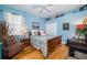 Cozy bedroom with blue walls, hardwood floors, and a floral patterned comforter at 18002 Forest Retreat Ln, Tampa, FL 33647