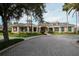 Exterior view of a clubhouse with a brick paved driveway, manicured landscaping, and architectural details at 18002 Forest Retreat Ln, Tampa, FL 33647