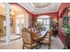 Formal dining room with elegant furniture, decorative lighting, and red accent wall at 18002 Forest Retreat Ln, Tampa, FL 33647