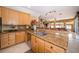 Bright kitchen with breakfast bar overlooking the living area, wooden cabinetry and granite countertop at 18002 Forest Retreat Ln, Tampa, FL 33647
