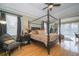 Spacious main bedroom suite with a four-poster bed and hardwood floors at 18002 Forest Retreat Ln, Tampa, FL 33647
