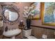 Elegant powder room featuring a pedestal sink, decorative mirror, and stylish wall decor for a touch of sophistication at 18002 Forest Retreat Ln, Tampa, FL 33647