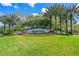 Community entrance sign with lush landscaping, flowers, and well-maintained lawns with blue skies overhead at 18002 Forest Retreat Ln, Tampa, FL 33647