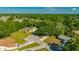 An aerial view shows a yellow home with a long driveway, surrounded by mature trees and lush landscaping at 23253 Granite Pl, Land O Lakes, FL 34639