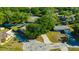 Aerial view of the neighborhood, lush landscaping, and a home with a well-maintained lawn and long driveway at 23253 Granite Pl, Land O Lakes, FL 34639
