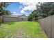 Fenced backyard with lush green grass and a screened porch, providing privacy and relaxation at 23253 Granite Pl, Land O Lakes, FL 34639