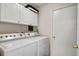 Clean and functional laundry room with washer, dryer, and overhead cabinets at 23253 Granite Pl, Land O Lakes, FL 34639