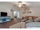 Comfortable living room with vaulted ceiling, wood-look flooring, a ceiling fan, and neutral-toned walls at 23253 Granite Pl, Land O Lakes, FL 34639