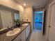 Bathroom featuring a granite countertop, double sinks, a large mirror, and a tile floor at 238 Argyll Dr, Spring Hill, FL 34609