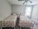 Shared bedroom with twin beds and matching floral comforters at 238 Argyll Dr, Spring Hill, FL 34609