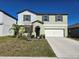 Two-story house with a two-car garage, neutral paint, and minimal landscaping for a clean, modern look at 238 Argyll Dr, Spring Hill, FL 34609