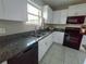 Well-lit kitchen features granite counters, stainless steel appliances, and ample cabinet space at 238 Argyll Dr, Spring Hill, FL 34609