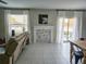 Living room with whitewashed fireplace, neutral walls, tile floors, and slider to outside at 238 Argyll Dr, Spring Hill, FL 34609