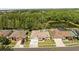 Aerial shot of homes with screened in pools and a serene pond surrounded by lush greenery at 28451 Great Bend Pl, Wesley Chapel, FL 33543