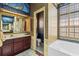 Bathroom showcasing beautiful tilework, cherry-wood vanity, and sunken bath at 28451 Great Bend Pl, Wesley Chapel, FL 33543