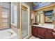Bathroom featuring a glass shower, cherry-wood vanity, and designer tilework at 28451 Great Bend Pl, Wesley Chapel, FL 33543